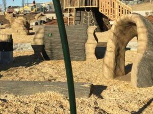 A playground piece that is in the shape of a cattail plant that spins around.