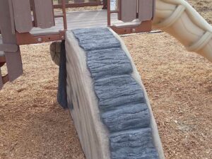 Sliced quarter wood chip climber is used as a deck access climber with a TreeLine play structure